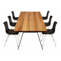 Wooden table with a natural finish paired with sleek black chairs featuring a minimalist design.