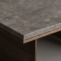 Gray textured tabletop with subtle patterns, featuring a sleek edge and warm brown base. Perfect for modern interiors.