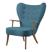 Modern blue upholstered chair with button tufting and light wooden legs, featuring a stylish wingback design.
