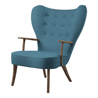 Turquoise upholstered armchair with button tufting and wooden legs, featuring a sleek and modern silhouette.