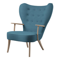 Turquoise blue upholstered armchair with tufted design and natural wood legs.