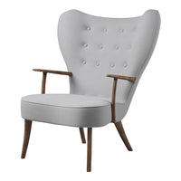 Grey tufted armchair with smooth, curved design and wooden legs, perfect for modern decor.