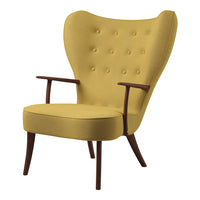 Vintage-inspired wingback chair in mustard yellow fabric with tufted detailing and wooden legs.