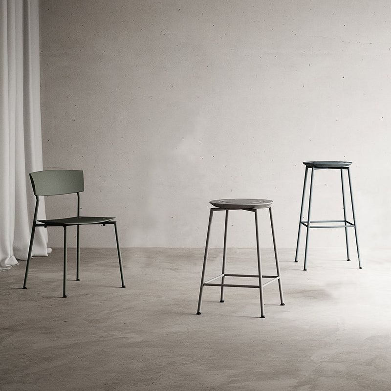 "Three metal chairs in muted green and gray tones, featuring minimalistic designs and sleek lines."
