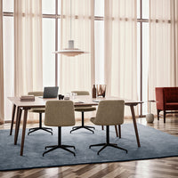 Modern dining set with beige chairs, a light wood table, and a blue textured rug, complemented by warm, neutral curtains.