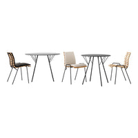 Modern dining set featuring black and beige chairs with wooden patterns and a sleek round glass table on black legs.