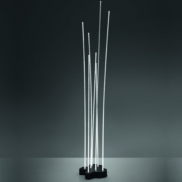 Modern floor lamp with sleek white LED rods on a black base, set against a dark backdrop.