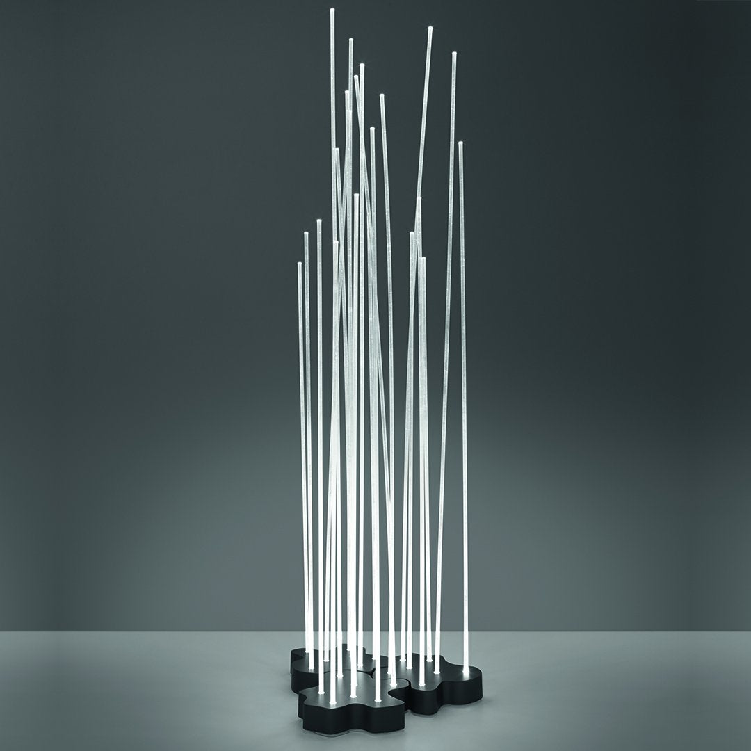 Modern metal sculpture with slim, vertical silver rods on a black base, showcasing a sleek, minimalist design.