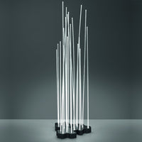 Modern metal sculpture with slim, vertical silver rods on a black base, showcasing a sleek, minimalist design.