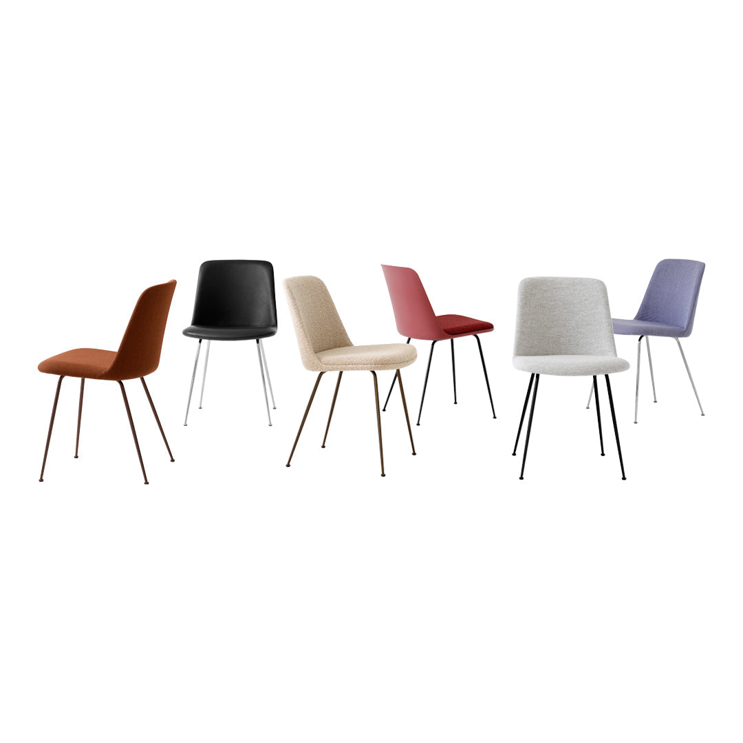 Colorful dining chairs in rust, black, beige, dusty rose, gray, and lavender with sleek metal legs.