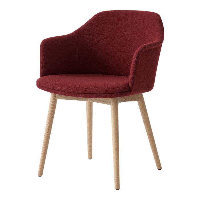 Burgundy upholstered chair with wooden legs, featuring a sleek, modern design and curved backrest.