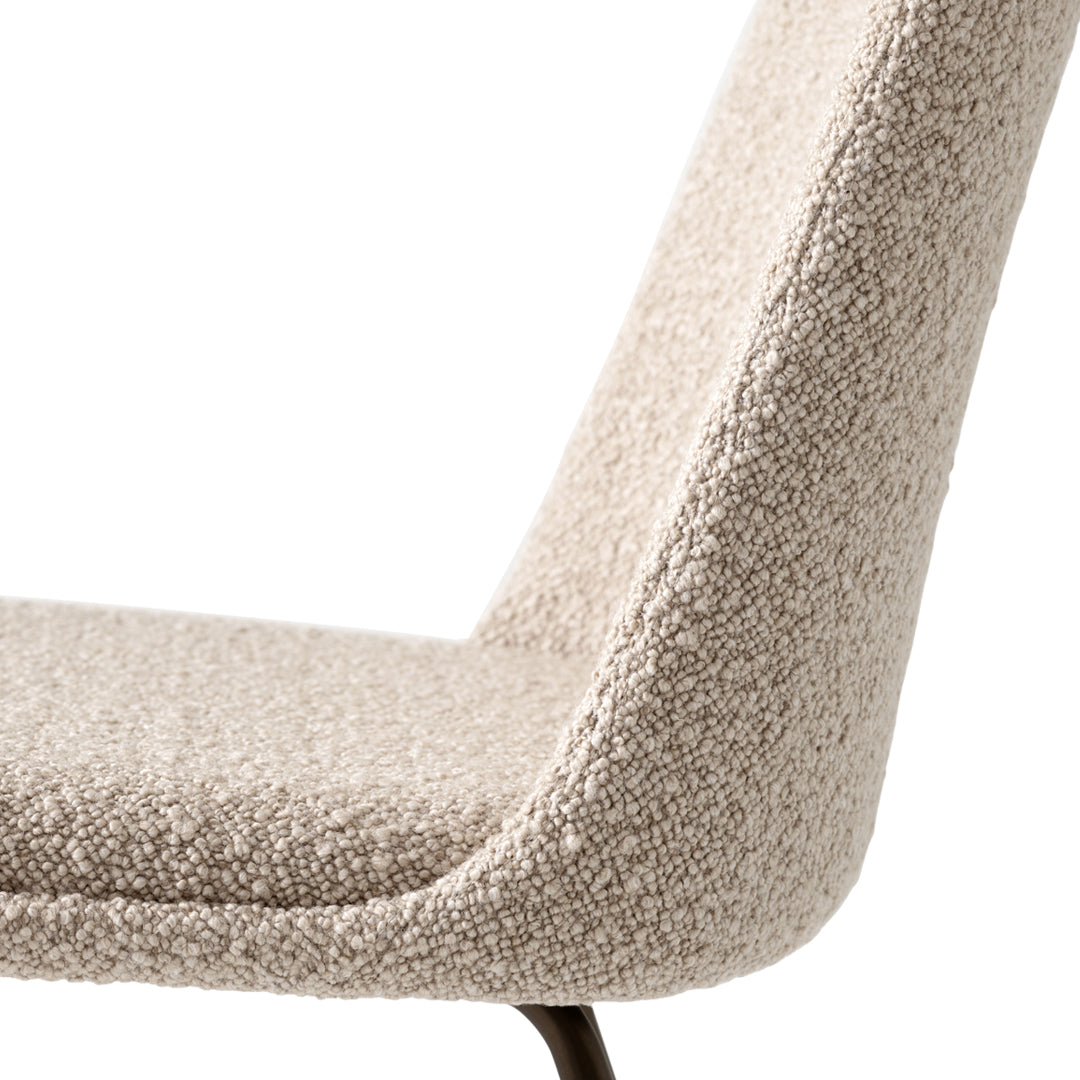 Textured beige fabric upholstery on a modern chair, featuring a sleek silhouette and a subtle woven pattern.