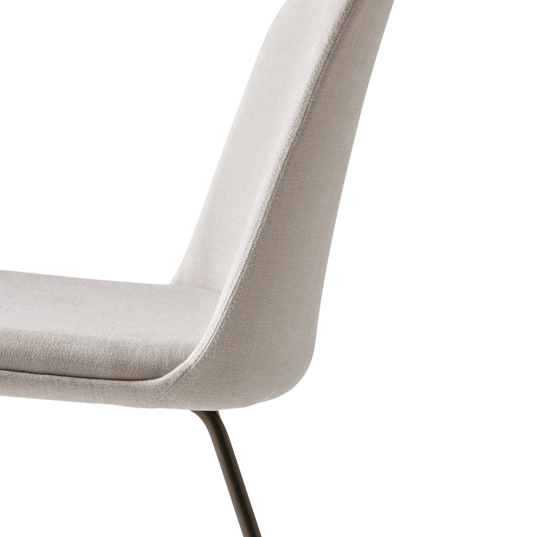 Light gray upholstered dining chair with sleek design and subtle texture, perfect for modern decor.