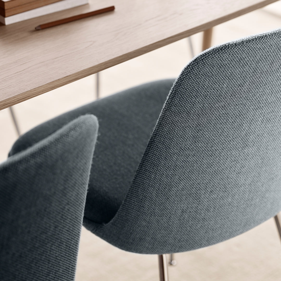 Gray upholstered chairs with a subtle woven pattern, complemented by a natural wood table.