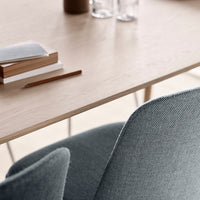 Light wood table with gray upholstered chairs, featuring a minimalistic design and soft, muted tones.