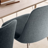 Gray upholstered chairs with a subtle woven pattern, complemented by a natural wood table.