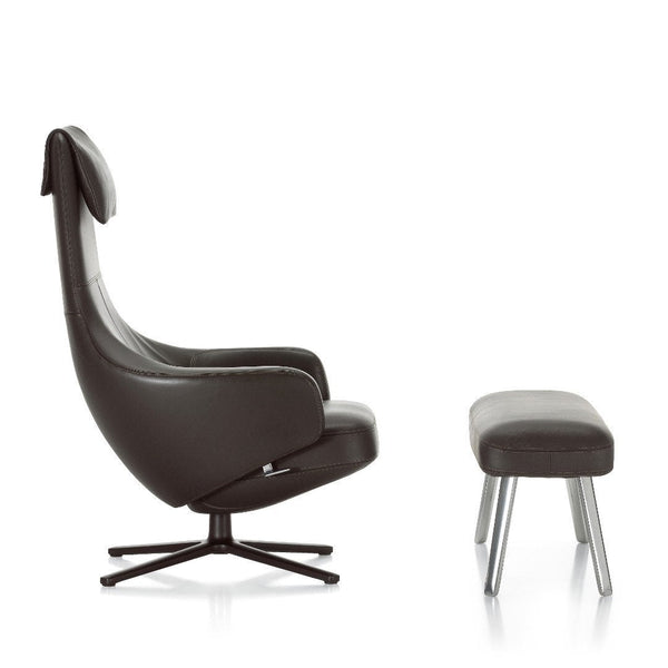 Modern black leather armchair with sleek lines and a matching ottoman in a minimalist design.