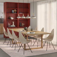 Modern dining room with neutral beige chairs, warm wooden table, and a vibrant red bookshelf against soft gray walls.
