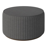 Round gray ottoman featuring vertical ribbed detailing and a smooth top surface, ideal for modern decor.