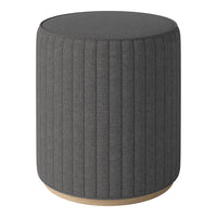 Gray upholstered round stool with vertical ribbed texture and light wood base. Stylish and modern accent piece.