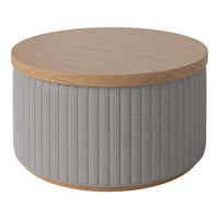 Round coffee table with a light wood top and soft gray ribbed fabric base. Stylish and modern design.