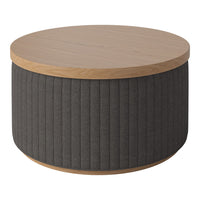 Round coffee table with a light wood top and charcoal gray ribbed fabric base. Modern, minimalist design.