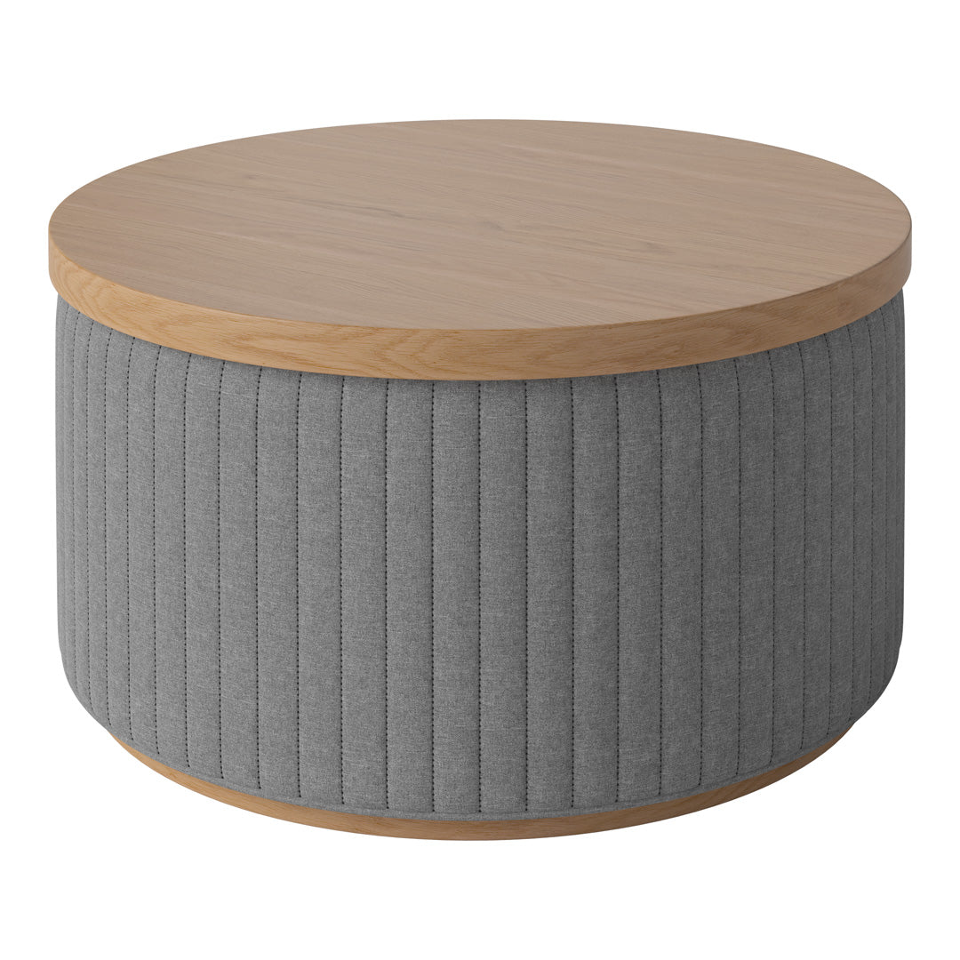 Round coffee table with a light wood top and textured gray ribbed fabric sides. Modern and stylish design.