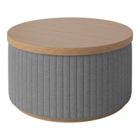 Round coffee table with a light wood top and textured gray ribbed fabric sides. Modern and stylish design.