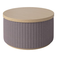 Round coffee table with a light wood top and vertical lavender fabric sides. Elegant and modern design, perfect for any décor.