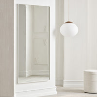 Sleek rectangular mirror with a minimalist silver frame, reflecting soft white wall and light tones.