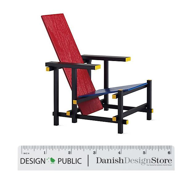 Colorful modern chair featuring red, blue, and yellow accents on a sleek black frame. Unique geometric design.
