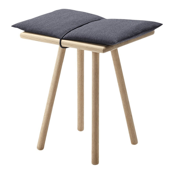 Gray cushioned seat on natural wood legs, featuring a minimalist design perfect for modern interiors.