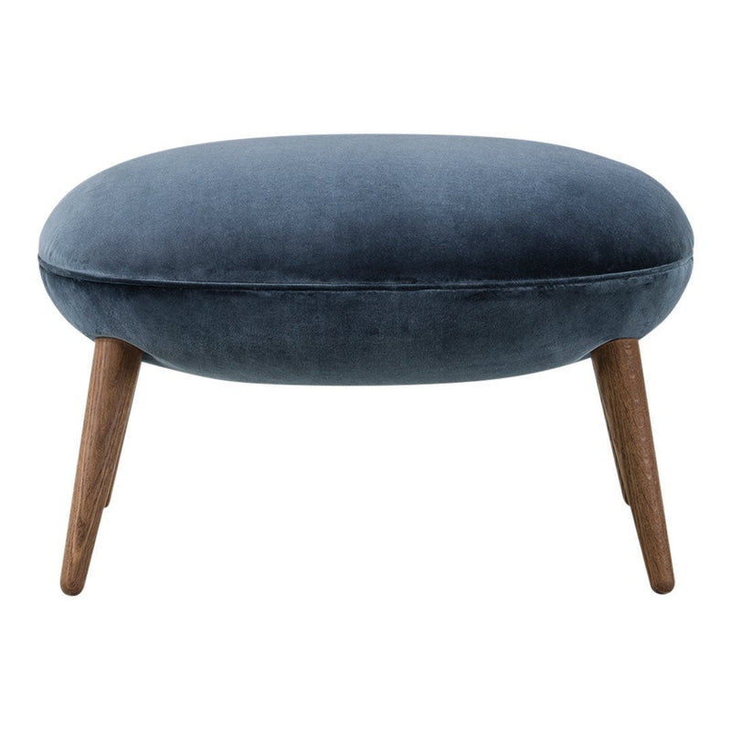 Round blue velvet ottoman with wooden legs, showcasing a smooth, sleek surface and modern design.