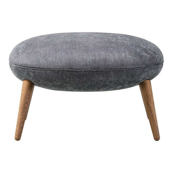 Gray upholstered ottoman with a smooth texture and natural wood legs, featuring a minimalist oval design.