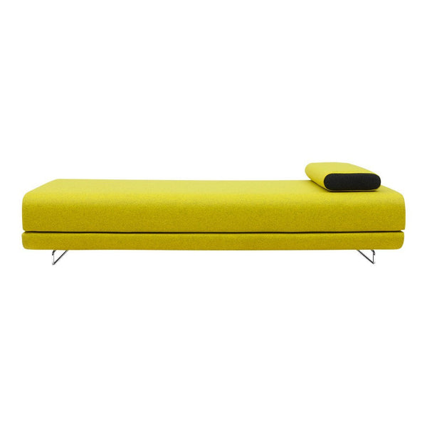Vibrant yellow chaise lounge with sleek black accent pillow and minimalist design. Perfect for modern decor.