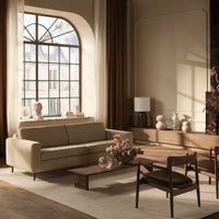 Light beige sofa, warm wooden accents, taupe curtains, and neutral tones create a cozy, modern living space.