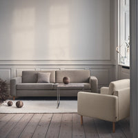 Gray and cream sofas with clean lines, set on a light wood floor, accented by soft textures and natural tones.
