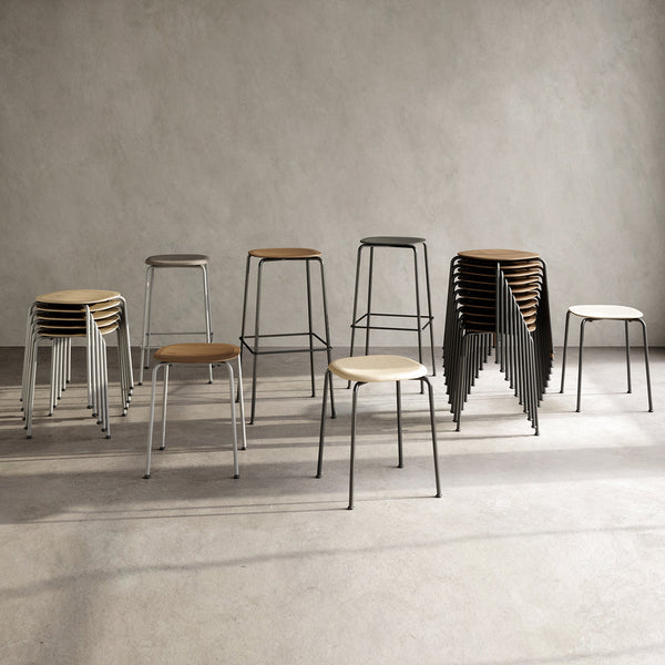 Assorted modern stools featuring beige wooden seats and sleek black and white metal frames. Stylish minimalist design.
