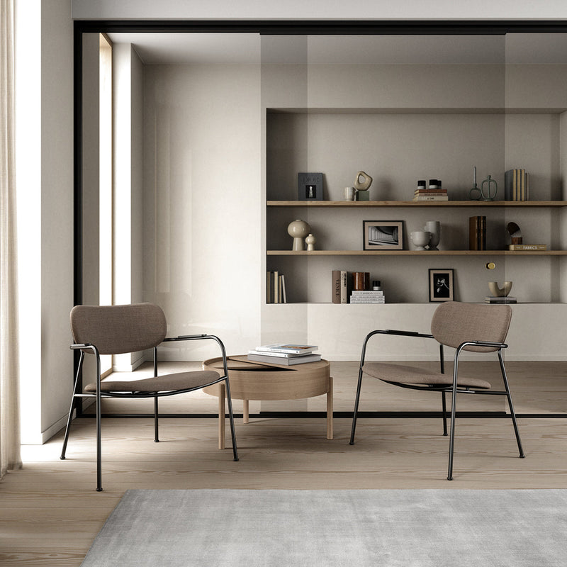 Modern beige armchairs with black metal frames, paired with a light wood coffee table in a minimalist living space.