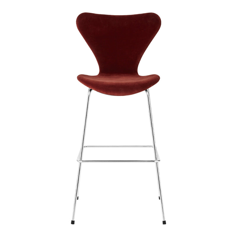 Red velvet bar stool with a sleek chrome base, showcasing a smooth, modern design. Ideal for stylish interiors.