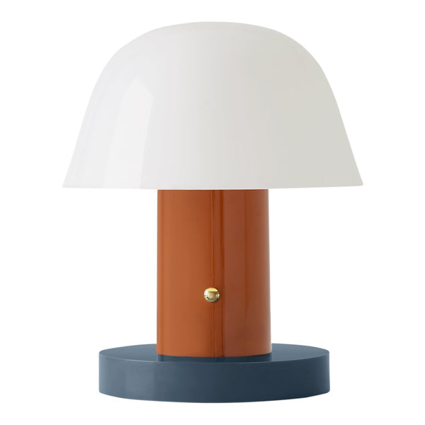 Modern lamp featuring a white dome shade, orange cylindrical base, and blue circular stand. Elegant color combination.