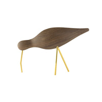Wooden bird figurine in rich brown with sleek yellow legs, showcasing a minimalist design and smooth contours.