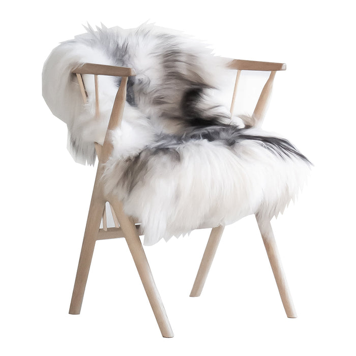 Cozy white faux fur chair with black and gray accents on a light wood frame, offering a modern, stylish look.