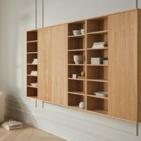Modern wooden wall shelf unit in light oak with minimalistic design and open and closed storage compartments.