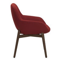 "Side view of a modern chair with a deep red fabric upholstery and dark wooden legs."