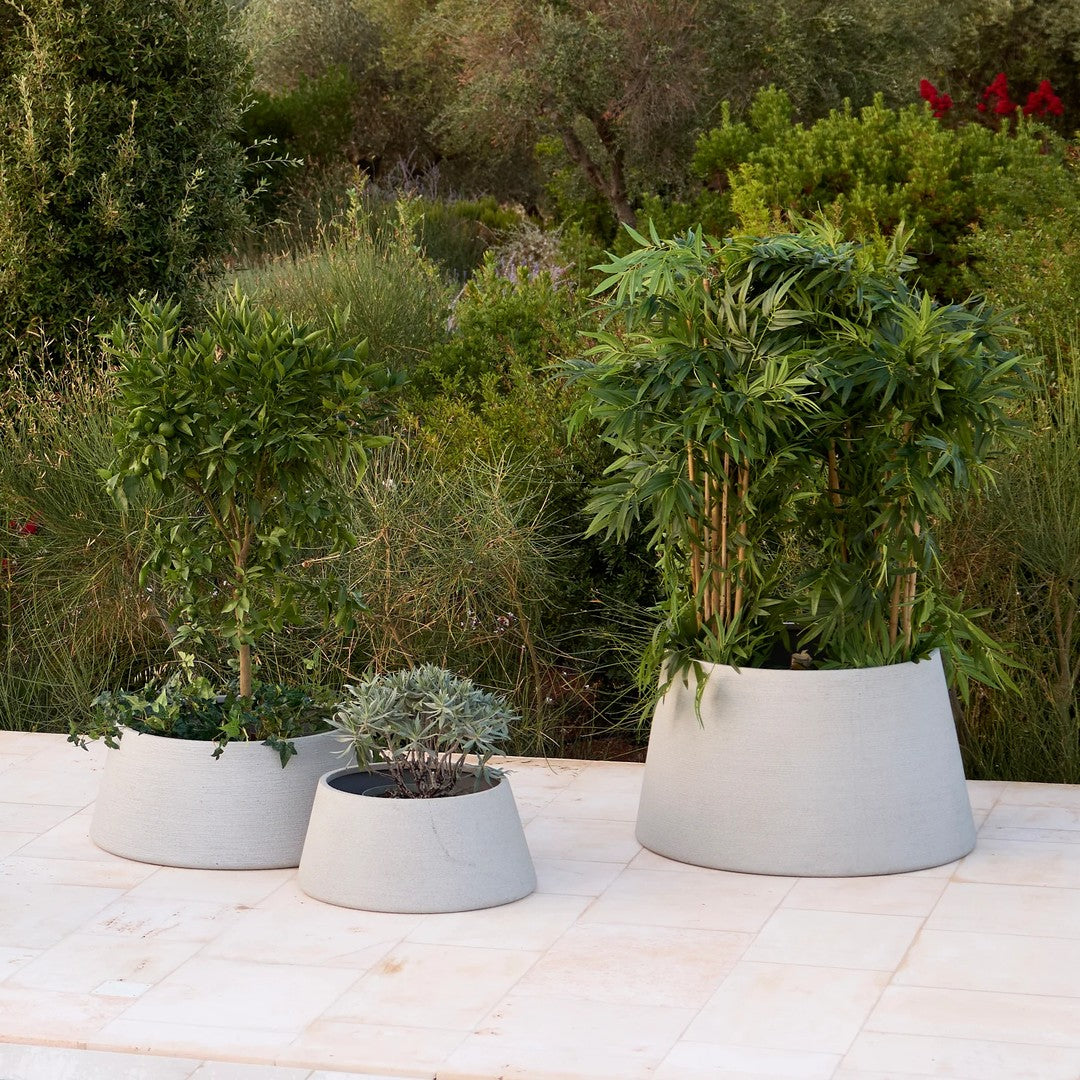 Set of three light gray planters with smooth, modern shapes, perfect for indoor or outdoor plants.