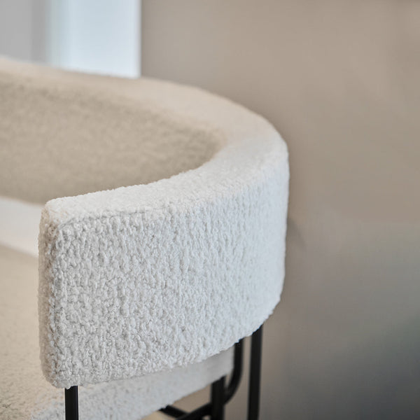 Textured cream upholstery with a soft, fuzzy finish on a modern round chair design.