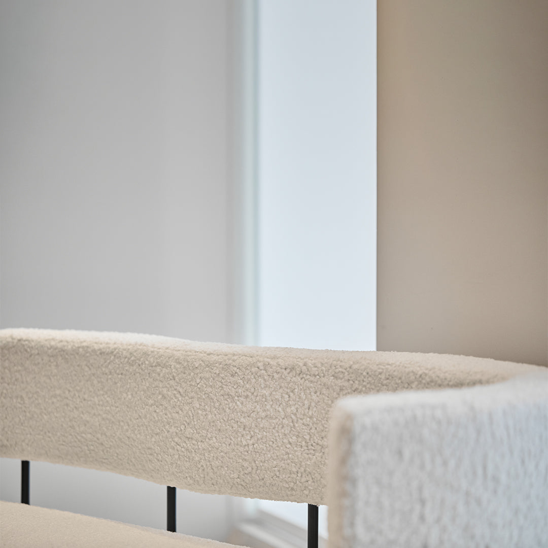 Textured white upholstered chair with a modern design, featuring a soft, cozy finish and sleek black metal accents.
