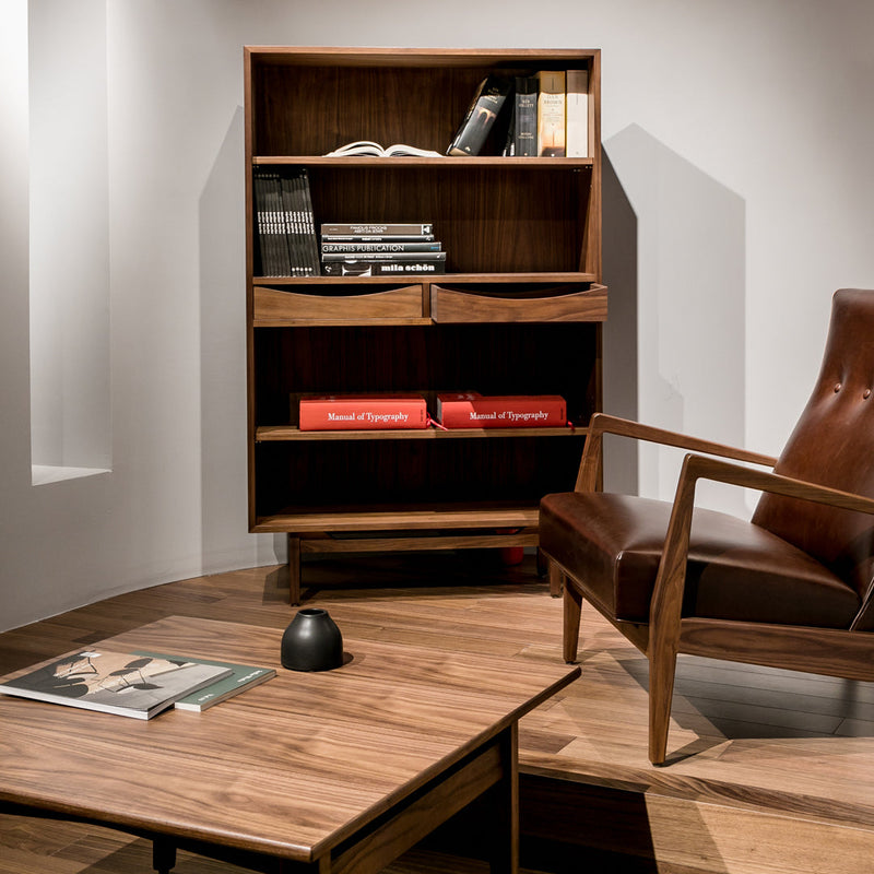 Mid-century modern bookshelf in rich walnut finish, featuring clean lines and contrasting warm red accents.