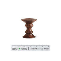 "Round wooden stool in rich brown finish with elegant curved pattern."